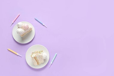 Lezzetli doğum günü pastası tabakları ve leylak arkaplanda mumlar.