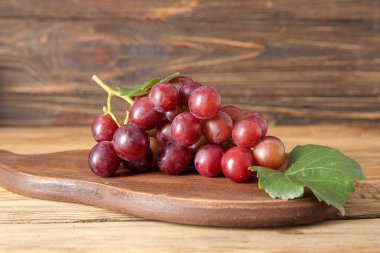 Ahşap arka planda lezzetli olgun üzümlü tahta.