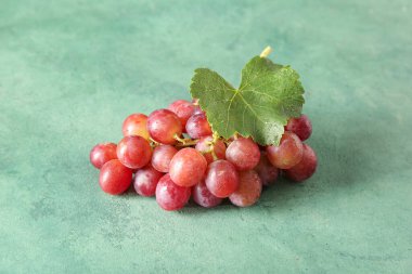 Yeşil arka planda yaprağı olan olgun üzümler.