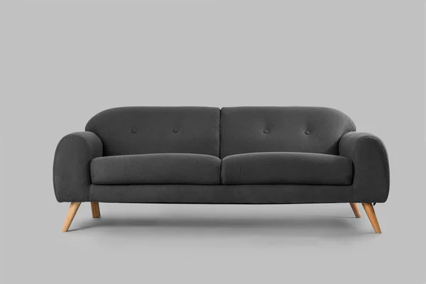 灰色背景的舒适的黑色沙发 — 图库照片