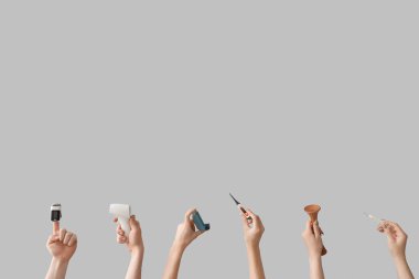 Gri arka planda tıbbi aletleri olan kadın eller