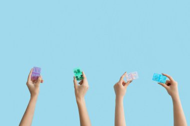 Mavi arka planda ilaç kutuları olan kadın elleri