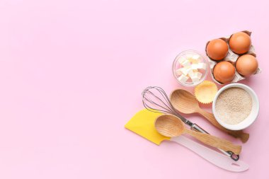 Pembe arka planda fırın hazırlamak için gerekli malzeme ve gereçleri içeren kompozisyon
