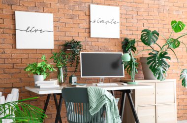 Modern işyeri ve ev bitkilerine sahip şık bir ofis.