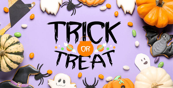 Halloween decor, sweets and text TRICK OR TREAT on lilac background