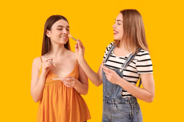 Amigos Sexo Feminino Fazendo Maquiagem Fundo Amarelo — Fotografia de Stock
