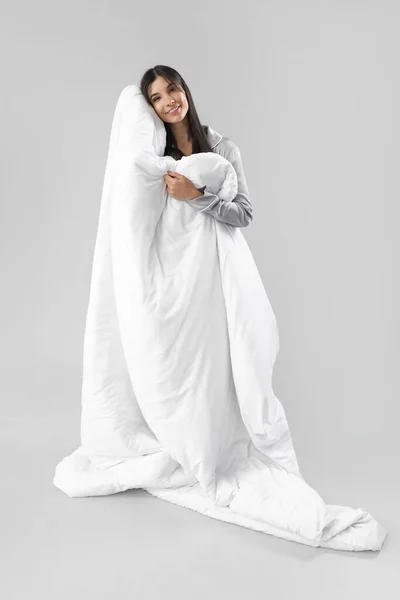 灰色の背景に柔らかい毛布が付いている美しい幸せな若い女性 — ストック写真