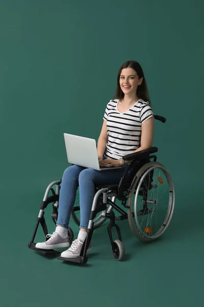Молодая Женщина Ноутбуком Инвалидной Коляске Зеленом Фоне — стоковое фото