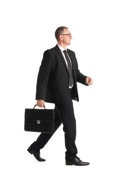 白い背景を歩くブリーフケース付き成熟したビジネスマン — ストック写真
