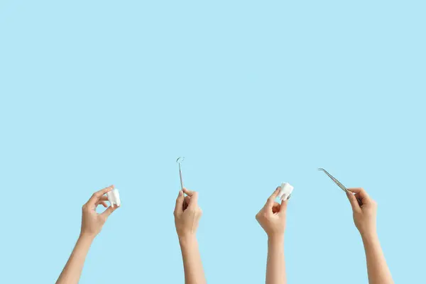 Mavi Arka Planda Dişçi Aletleri Diş Modelleri Olan Kadın Elleri — Stok fotoğraf