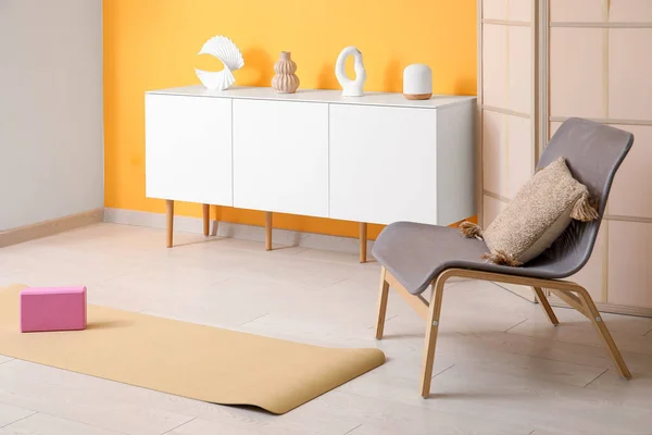 Interior of living room with chair and yoga equipment