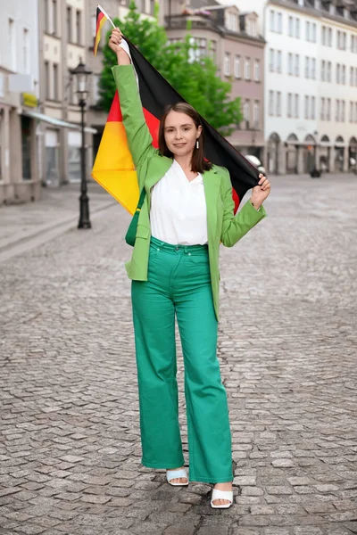 Young woman with flags of Germany on city street