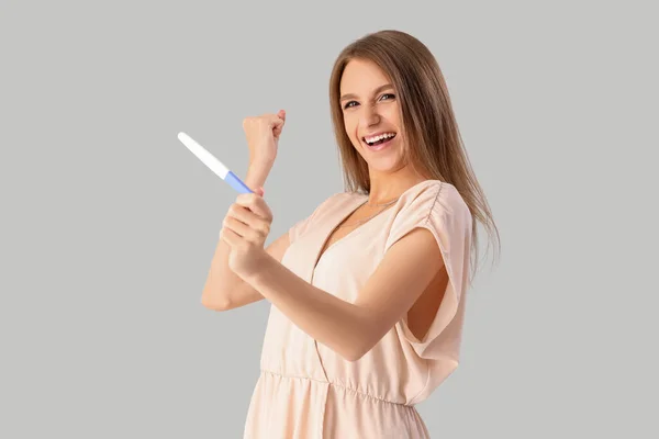 Glücklich Schöne Junge Frau Mit Schwangerschaftstest Auf Grauem Hintergrund — Stockfoto