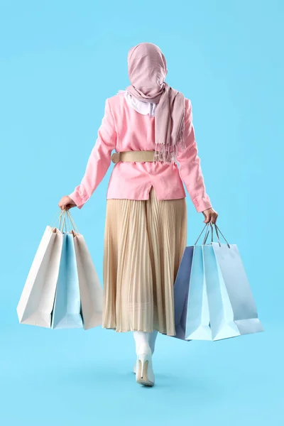 Мусульманская Женщина Пакетами Ходить Синем Фоне Вид Сзади — стоковое фото