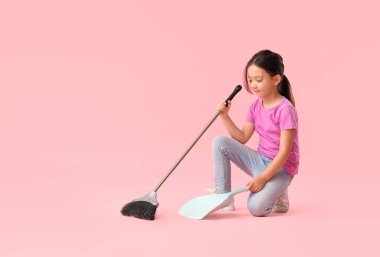 Pembe arka planda paspası olan sevimli küçük bir kız.