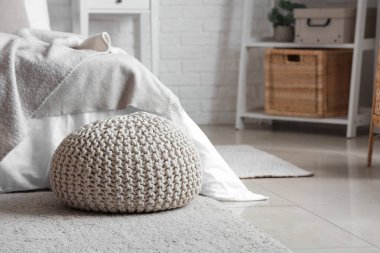 Yatak odasında yerde örülmüş puf, yakın plan.