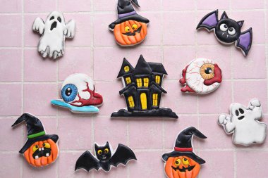 Cadılar Bayramı için farklı lezzetli kurabiyeler. Pembe fayans arka planda.