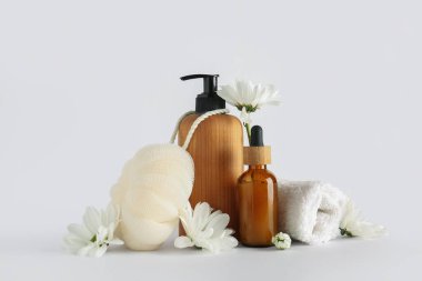 Banyo malzemeleri ve beyaz arka planda papatya çiçekleri olan kompozisyon