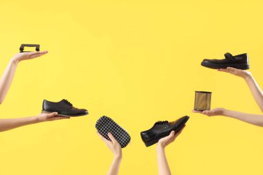 Farklı kırtasiye malzemesi ve sarı arka planda okul ayakkabısı olan birçok kadın eli.