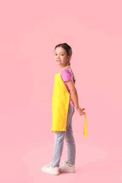 Симпатична Маленька Дівчинка Зав Язує Фартух Рожевому Фоні — стокове фото