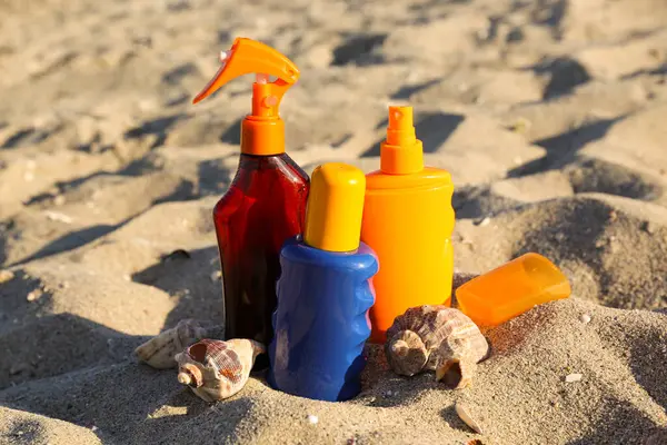 Flaschen Sonnencreme Mit Muscheln Auf Sand Strand — Stockfoto