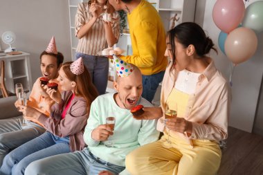 Bir grup genç arkadaş evde doğum gününü kutluyor.