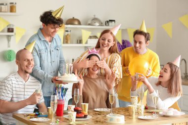 Genç adam partideki arkadaşına doğum günü pastası getiriyor.