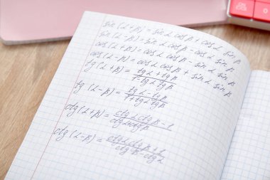 Matematik formülleriyle birlikte ahşap masada, yakın plan defterini aç