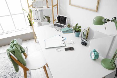 Ofisinde dizüstü bilgisayarı ve kırtasiyesi olan modern işyeri