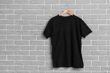 Gri duvarda asılı şık siyah tişört