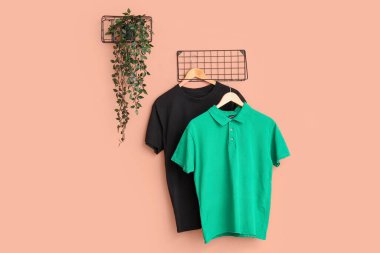 Pembe arka planda asılı şık tişörtler