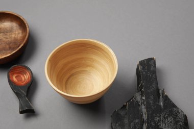 Gri arkaplanda farklı ahşap sofra takımı, yakın plan