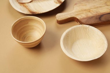 Bej arkaplanda farklı ahşap masa takımı, yakın plan