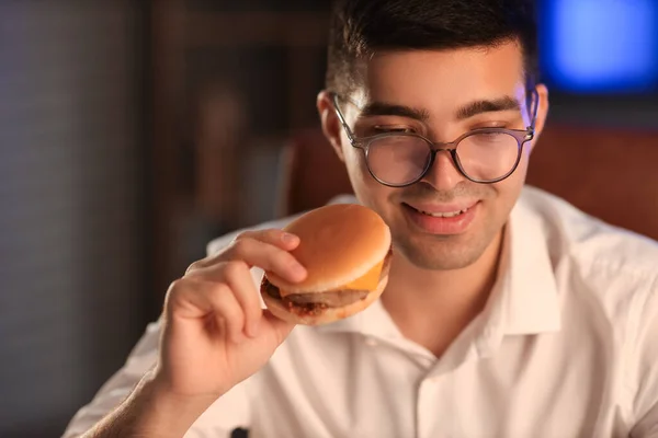 Fiatal Üzletember Finom Hamburgerrel Irodában Éjszaka Közelkép — Stock Fotó