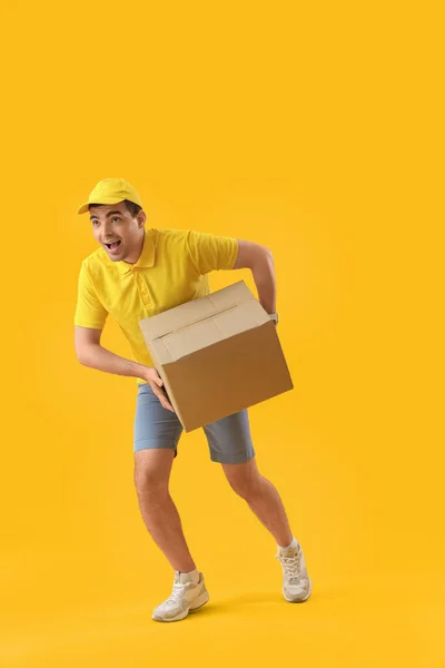 Männlicher Kurier Mit Paket Läuft Auf Gelbem Hintergrund — Stockfoto