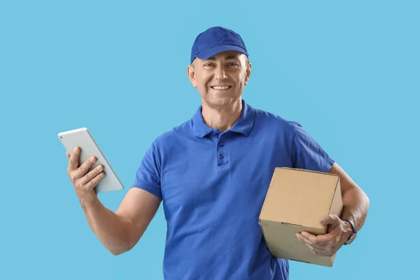 青い背景にタブレットコンピュータと小包が付いている成熟した宅配便 — ストック写真