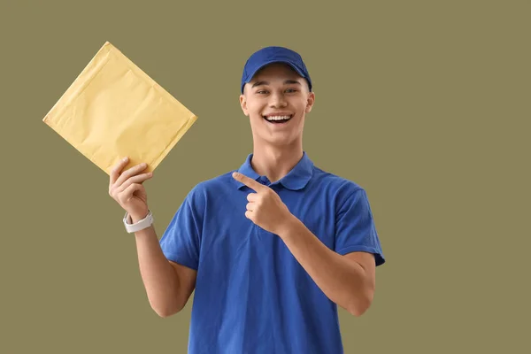 Young Courier Pointing Envelope Green Background — Stock Photo, Image