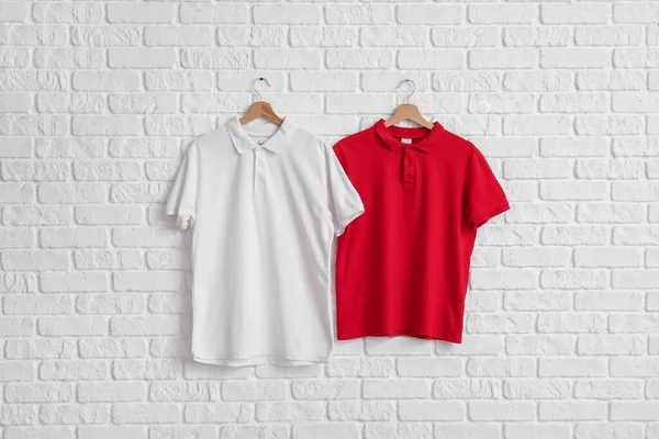 Stijlvolle Shirts Hangend Aan Witte Bakstenen Muur — Stockfoto