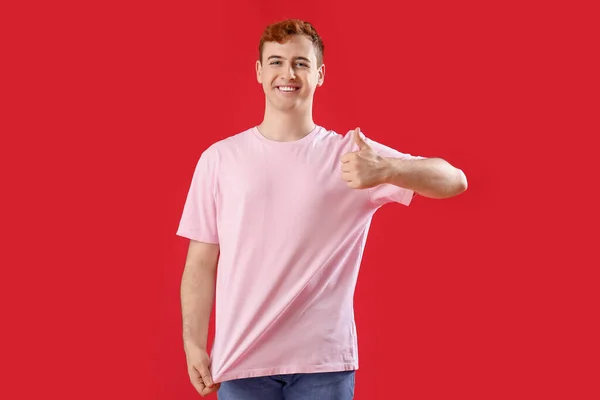 Ung Man Shirt Visar Tummen Upp Röd Bakgrund — Stockfoto
