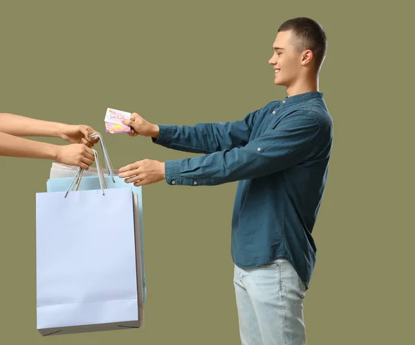 Νεαρός Άνδρας Κάρτες Δώρων Λαμβάνοντας Τσάντες Ψώνια Στο Πράσινο Φόντο — Φωτογραφία Αρχείου