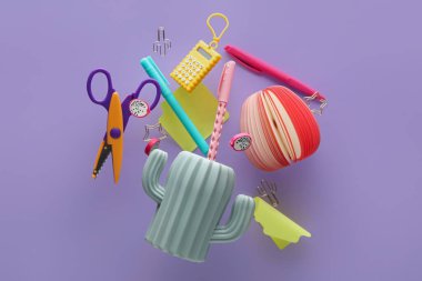 Leylak arka planında uçan farklı kırtasiye malzemesi olan tutucu