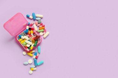 Leylak arka planında farklı haplar olan bir kap.