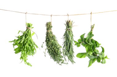 Beyaz arka planda ipte sallanan taze otlar.