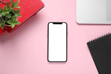 Pembe arka planda modern cep telefonu ve defterler