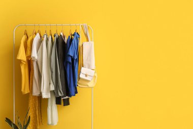 Sarı duvarın yanında farklı kıyafetlerle dizilin.