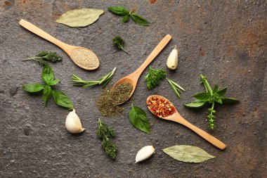 Baharat kaşıkları ve arkaplanda taze otlar olan kompozisyon.