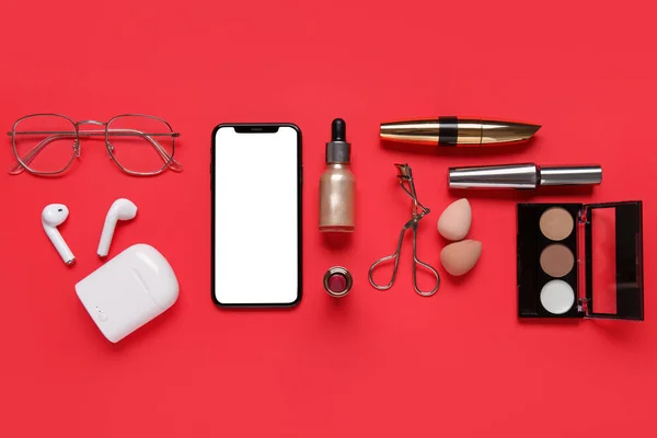 Composition Modern Mobile Phone Earphones Cosmetic Products Red Background — Stock Photo, Image