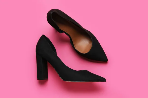 Stylish black high heels on pink background