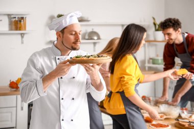 Mutfaktaki aşçılık kursunda pizza hazırlayan İtalyan şef.