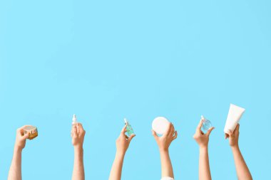 Mavi arka planda kozmetik ürünleri olan kadınlar